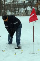 man golfing in snow