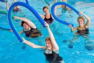 swimmers exercising in pool with foam noodles